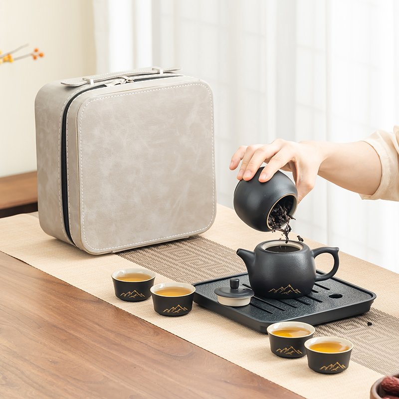 Loose tea leaves being poured from the opened ceramic tea jar into the black ceramic teapot