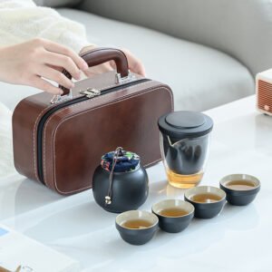 Brown carrying case beside a black travel tea set with clear pitcher, four cups and covered tea jar