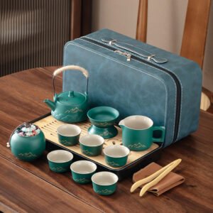 Green travel tea set with a wrapped-handle teapot, pitcher, six displayed cups, tea jar, strainer, tray and teal case