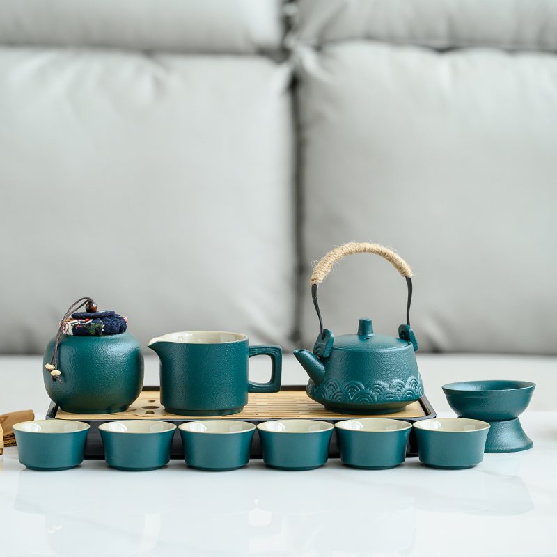 Teal ceramic teapot, pitcher, cups, storage jar and strainer on tray
