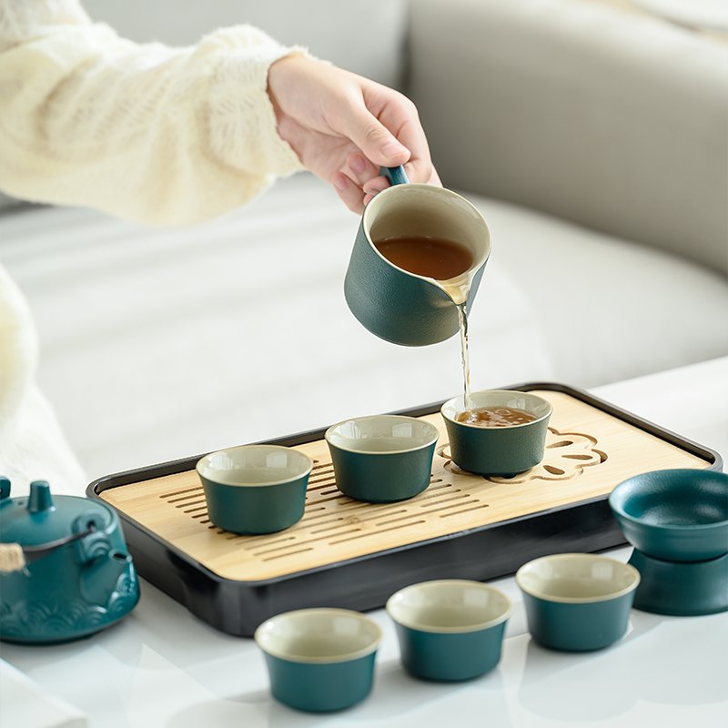 Fairness pitcher pouring tea into teal ceramic cups
