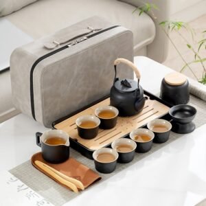 Black ceramic travel tea set with six cups, an overhead-handle teapot, a tea tray and a gray carrying case